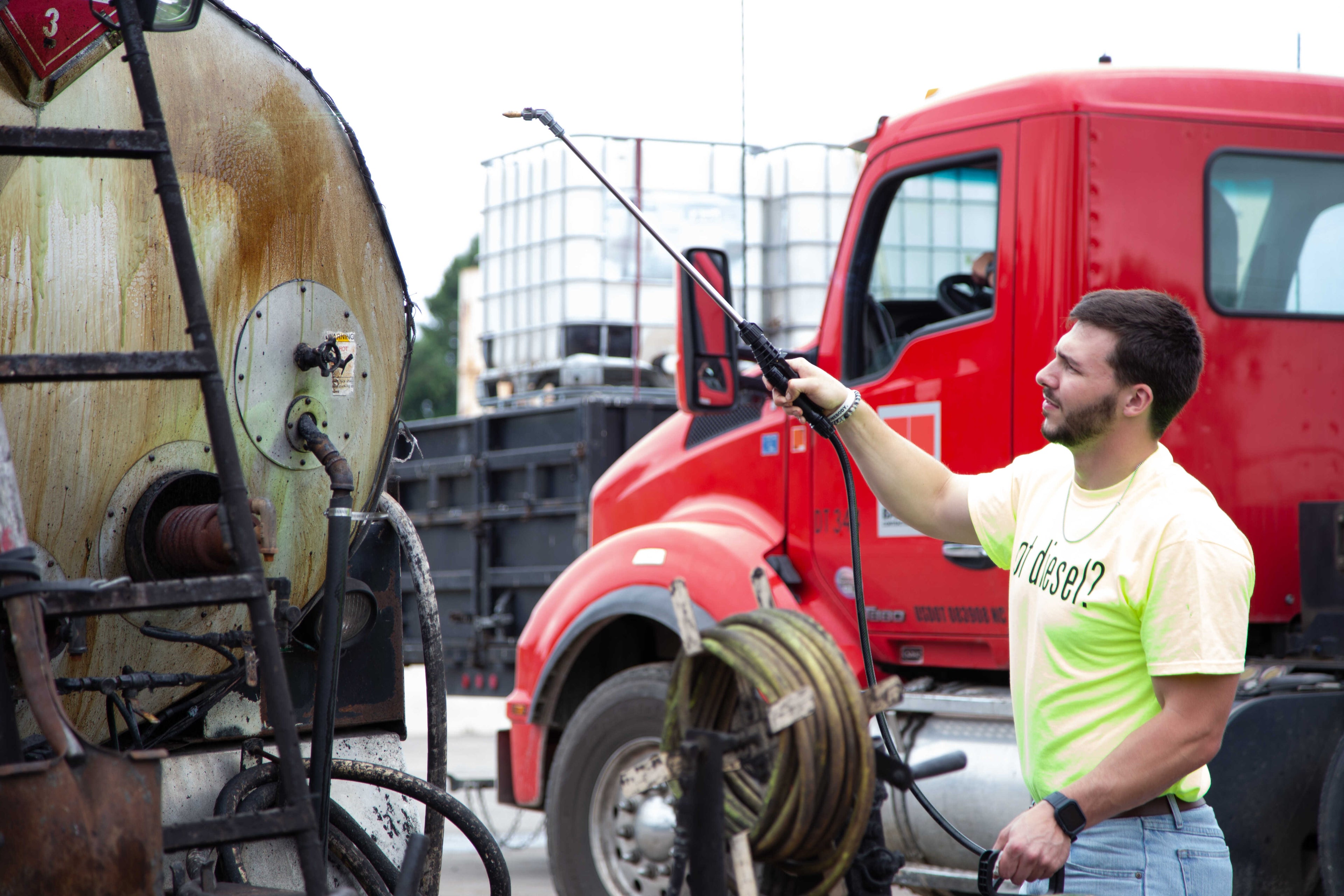 Josh sprays PavePro onto the back of a tack truck. 